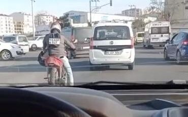 Plakayı sırt çantasına taktı